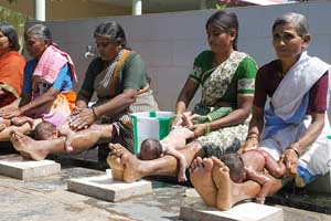 mujeres bañando a niños en anantapur