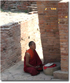 monje meditando en la estupa Dharmarajija en Sarnath
